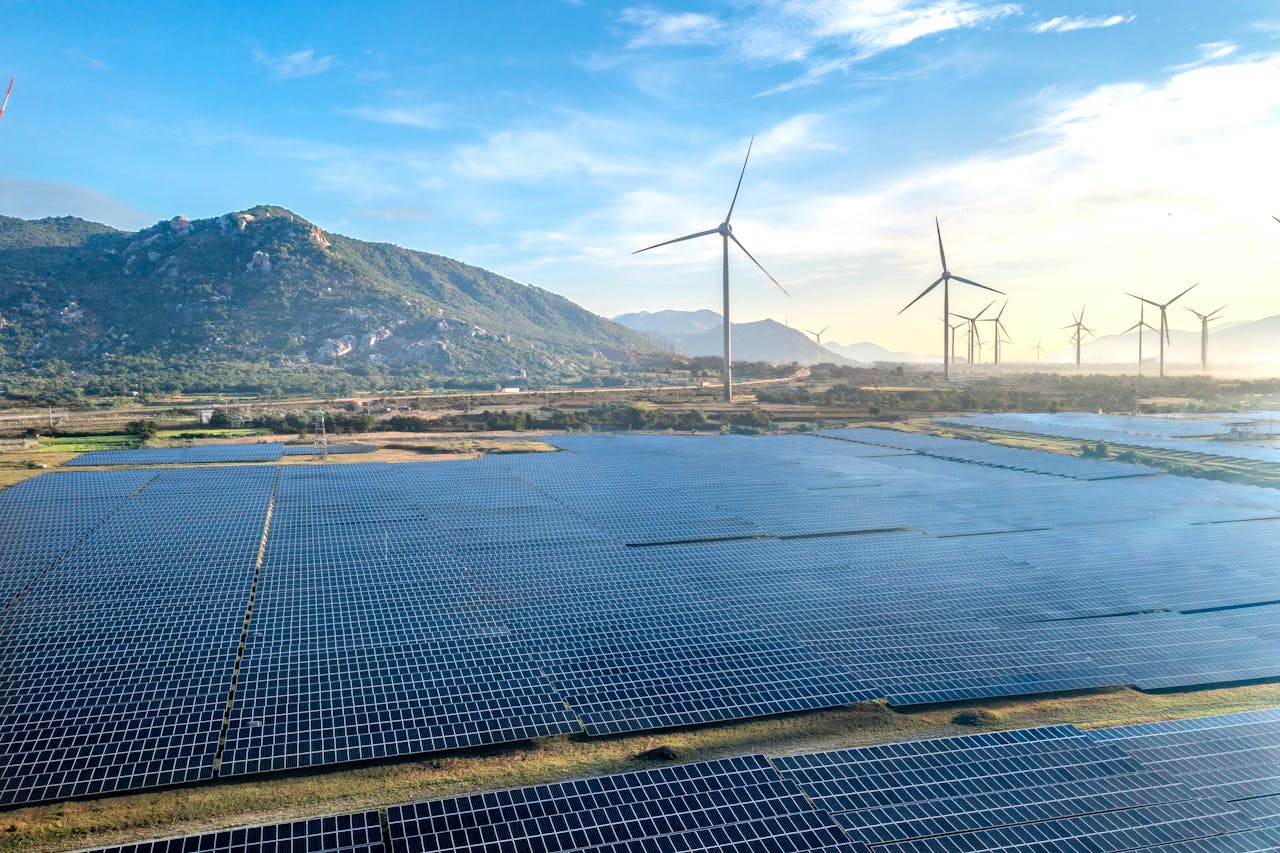 Aerial view of a solar and wind energy farm set against Vietnam's scenic landscape.